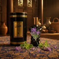 Volare Elixir Gladiator Twilight 100ml Man — Black cylindrical container with gold stripes and label, next to a black torso-shaped perfume bottle with lavender and mint sprigs on a patterned cloth.