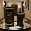 Volare Elixir Gladiator Twilight by Volare 100ml Man — Black torso-shaped perfume bottle with gold cap and matching cylindrical box on a silver tray, with a small white card.