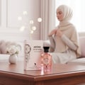 Volare Arome de Reverie by Volare – 100 ml for Her Eau de Parfum, dipamerkan bersama kotaknya di atas meja kayu, dengan wanita bertudung kabur di latar belakang.
