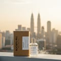 Volare Society 974 Volare 100 ml EDP Unisex — A brown cardboard box and a clear glass perfume bottle with a beige cap, both labeled 'SOCIETY 991', sit on a ledge with a blurred city skyline and twin towers in the background.