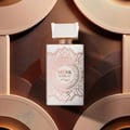 Zimaya Musk Is Great by Zimaya 100ml EDP Unisex — White perfume bottle with rose gold geometric pattern and cap, set against a textured brown and rose gold background with circular elements.