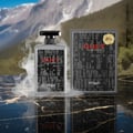 Zimaya Cult by Zimaya 100ml EDP Men — Botol Zimaya Cult Eau de Parfum bersama kotaknya, dilitupi asap, berlatar belakang pemandangan gunung dan pantulan di permukaan marmar.