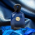 Zimaya Evolution by Zimaya 100ml EDP For Men — Blue glass perfume bottle with gold emblem and blue gem on black cap, set against a textured blue leather background and draped blue fabric.