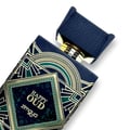 Zimaya Happy Oud by Zimaya 100ml Extrait Unisex — Botol minyak wangi biru gelap dengan reka bentuk art deco emas dan hijau, tertulis 'HAPPY OUD zimaya'. Penutup biru gelap terbuka dan condong.