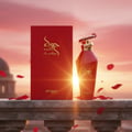 Zimaya Hawwa Red by Zimaya 100ml EDP Women — Red perfume bottle and box displayed on a stone ledge with rose petals falling against a sunset sky.