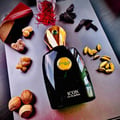 Zimaya Icon by Zimaya 100ml EDP for Men — Botol minyak wangi hitam dengan penutup emas dan permata hijau, dikelilingi oleh saffron, buah pelaga, buah pala, dan serpihan kayu oud.