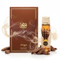 Zimaya Itqan Gold by Zimaya 100ml EDP Unisex — Kotak coklat reka bentuk sayap helang dan tulisan Arab, bersama botol minyak wangi bertutup emas, dikelilingi serpihan kayu dan kepulan asap.