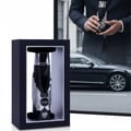 Zimaya Itqan Noir by Zimaya 100ml EDP Men — Black perfume bottle with silver wings in a black display box, with a man in a suit holding another bottle and a black car in the background.