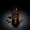 Zimaya Night Shadow by Zimaya 100ml EDP Unisex — Amber glass perfume bottle with gold accents, paired with silver square cufflinks and scattered oud wood chips on a black textured surface.