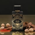 Zimaya Oud Is Great by Zimaya 100ml EDP Unisex — Black perfume bottle with gold geometric design, gold cap, surrounded by oud wood chips, nutmeg, and red spice powder.
