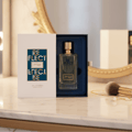 Zimaya Reflect by Zimaya 100ml EDP Unisex — A clear glass perfume bottle with a gold cap, presented in an open navy blue box, with a white outer sleeve showing the product name in gold and teal.