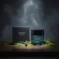 Zimaya Reserved Black Cedar by Zimaya EDP 100 ml — A black textured box and a blue glass perfume bottle with a black cap, surrounded by green cedar branches and pinecones on a wooden surface, with smoky wisps in the dark background.