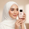 Zimaya Yaa Umree by Zimaya EDP 100 ml Women — Woman in white hijab holding a light pink perfume bottle with a black cap, showing the label.