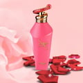 Zimaya Hawwa Pink by Zimaya Women 100ml EDP — Pink perfume bottle with a gold and red patterned cap, surrounded by red rose petals on a pink background with draped fabric.