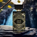 Zimaya Oud Is Great by Zimaya 100ml EDP Unisex — Black and gold art deco perfume bottle with ornate geometric design, set on dark textured rocks with a blurred waterfall and foliage background.