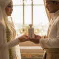 Ard Al Zaafaran Ghality by Ard Al Zaafaran 100ml EDP Women — Bride and groom holding a floral perfume bottle during a