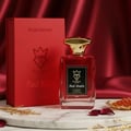 Bujairami Red Eclipse by Bujairami 100ml EDP — Red perfume bottle with gold cap, next to its red presentation box, on a marble surface with gold accents and rose petals.