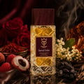 Bujairami Sacred Order by Bujairami 100ml Extrait — Clear glass perfume bottle with a dark wooden cap, featuring a maroon label with gold crown and text. Surrounded by red roses, saffron threads, lychees, white flowers, and dark raisins.