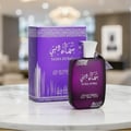 Ard Al Zaafaran Sama Dubai 100ml — A purple perfume bottle and its matching box are displayed on a marble surface with a blurred background of a room with chandeliers. | Ard Al Zaafaran Sama Dubai 100ml — Sebotol dan kotak minyak wangi berwarna ungu dipamerkan di atas permukaan marmar dengan latar belakang bilik yang