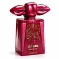 Asdaaf Sougha — A metallic red perfume bottle with a unique, sculpted cap resembling lips or wings, adorned with scattered gold flecks on the front.