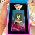 Bujairami Soul Fusion Intense — A rectangular iridescent perfume bottle with a gold crown logo and 'B' inside, set in a blue and pink gradient box, held by a hand with a gold bracelet.