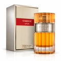 Afnan Stardust by Afnan 100ml Extrait Unisex — Botol minyak wangi kaca berjalur emas dengan penutup oren berbingkai dan jalur perak, berdiri bersebelahan kotak emas bertekstur dan merahnya.