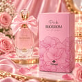 TADangel Pink Blossom 100ml EDP Women — A pink perfume bottle with a satin bow and crystal cap, next to its pink floral-patterned box, surrounded by pink roses and satin fabric.