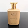 Paris Corner Taskeen Caramel Cascade 100ml — A square, tan perfume bottle with a gold cap, featuring Arabic script and "TASKEEN" above "Caramel Cascade" and "PARIS CORNER" | Paris Corner Taskeen Caramel Cascade 100ml — Botol minyak wangi segi empat, berwarna tan dengan penutup emas, menampilkan tulisan Arab dan