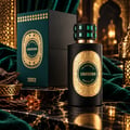 French Avenue Unknown Absolus Les Extraits — Botol minyak wangi hitam berlabel emas berukir dan penutup permata hijau, bersebelahan kotak hijau gelap dan emasnya, di atas permukaan marmar dengan serpihan kayu oud dan permata amber.