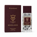 Bujairami Woodlands by Bujairami Extrait de Parfum 100ml — A maroon box and a clear, faceted glass perfume bottle with a maroon cap, both featuring gold branding and the 'B' crown logo.