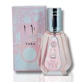 Ard Al Zaafaran Yara Eau De Parfum 50ml — Pink floral patterned box next to a pale pink faceted glass perfume bottle with a silver cap. | Ard Al Zaafaran Yara Eau De Parfum 50ml — Kotak bercorak bunga merah jambu di sebelah botol minyak wangi kaca merah jambu pucat berfaset dengan penutup perak.