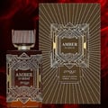 Zimaya Amber Is Great Eau De Parfum 100ml — A brown glass perfume bottle with a ribbed cap and ornate gold geometric detailing, standing next to its matching brown and gold patterned box with art deco inspired design. | Zimaya Amber Is Great Eau De Parfum 100ml — Botol kaca perang dengan penutup berjalur dan perincian