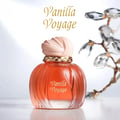 Maison Asrar Vanilla Voyage — Botol minyak wangi ton keladak dengan penutup merah jambu bertekstur dan kolar jalinan emas, berlatar belakang putih terang dengan dahan kristal kabur.