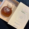 Maison Asrar Vanilla Voyage — Botol minyak wangi berwarna ambar dengan penutup bertekstur dan trim emas, diletakkan dalam kotak beige terbuka bersebelahan kotak produk sepadan dengan butiran timbul.