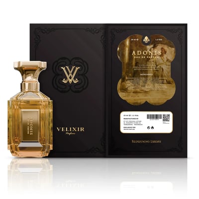 Velixir Adonis 100ml EDP — A golden glass perfume bottle with a gold cap stands next to its black and gold packaging box, which features ornate designs and product information. | Velixir Adonis 100ml EDP — Sebotol minyak wangi kaca keemasan dengan penutup emas berdiri di sebelah kotak pembungkusnya yang berwarna hitam