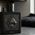 Rayhaan Wolf by Rayhaan 100ml EDP for Men — Black perfume bottle with a detailed wolf emblem on the front, black cap, set on a grey surface next to a dark folded shirt.